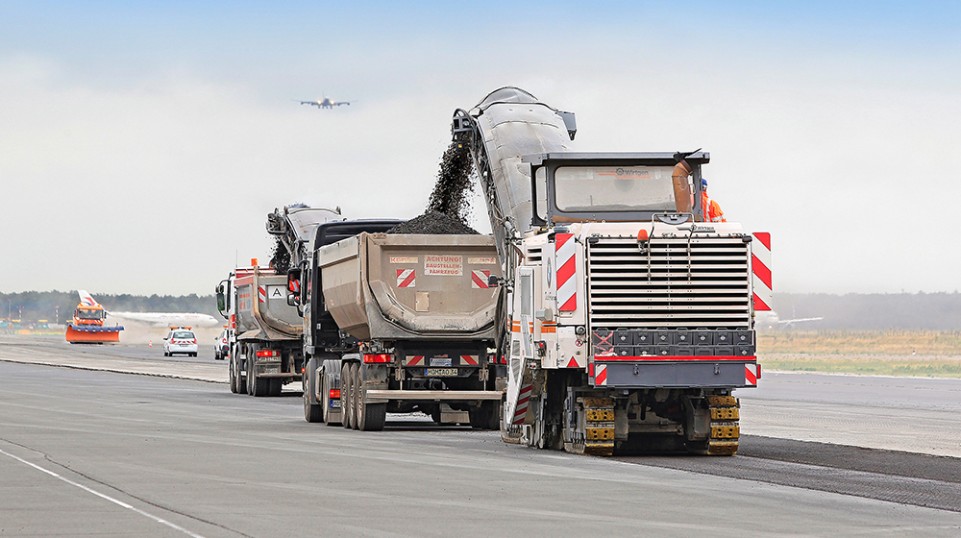Two large milling machines – one team. A Wirtgen W 250i and W 2000 at Frankfurt Airport, milling off the surface course to a depth of 5 cm, working just a few meters apart, offset one behind the other