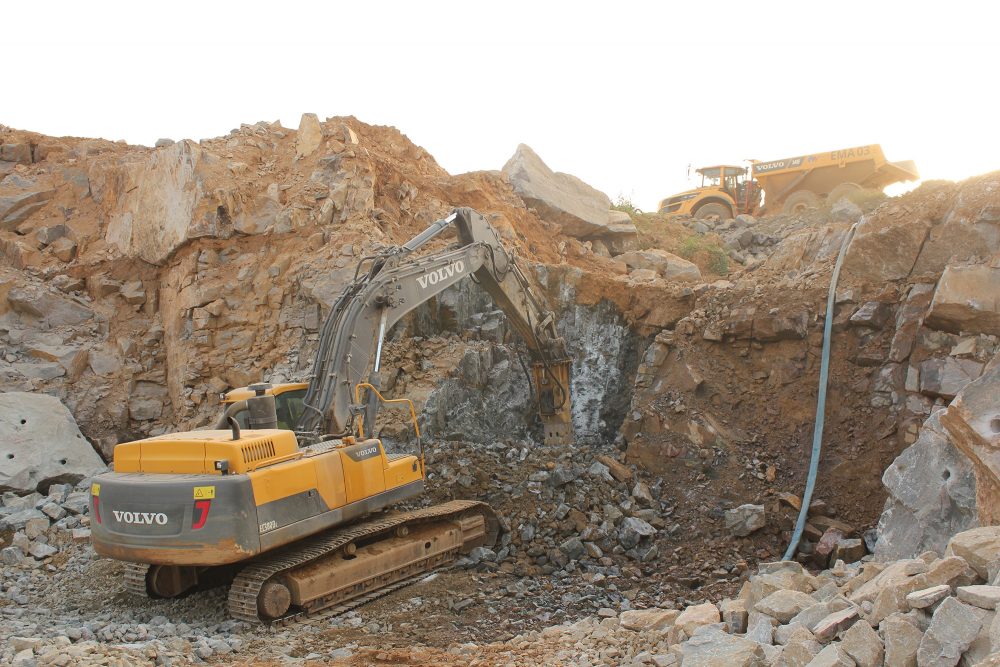 An EC380DL Crawler Excavator uses an HB38 hammer attachment to displace the kimerlite and break it up into manageable pieces.