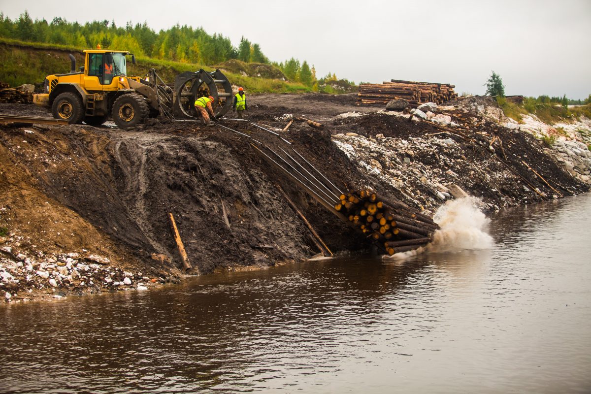 The Volvo L120 wheel loader unloads the logs, reading for arranging in the raft.