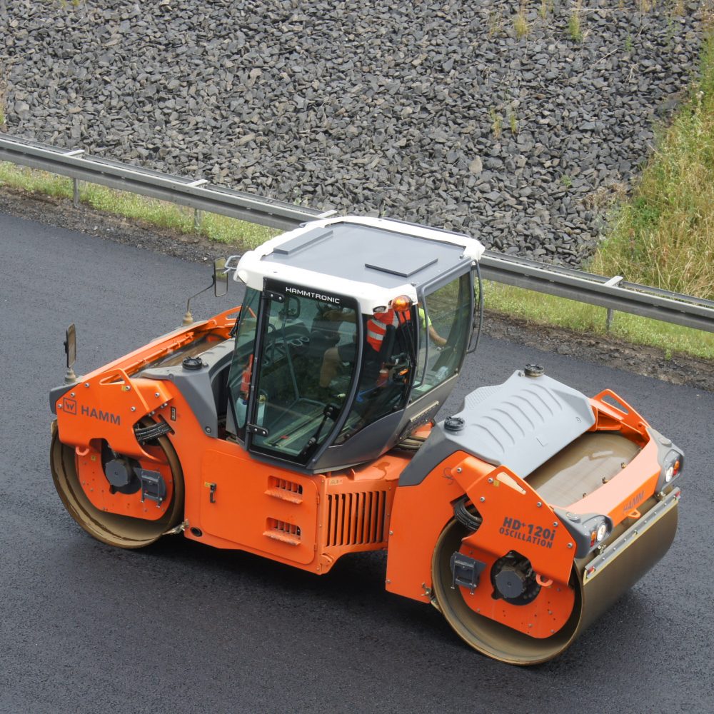 A HAMM HD+ 120i OV tandem roller compacting the surface course of a busy highway: thanks to oscillation, compaction increases very rapidly, and an exceptionally smooth surface is produced.