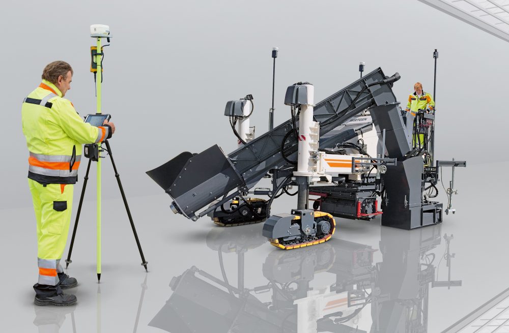 The 3D control system comprises a computer integrated into the paver and a tablet attached to the Field Rover survey pole. Two GPS receivers mounted on the machine communicate with a GPS reference station at the job site.