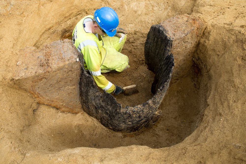 an archaeologist examines an Anglo-Saxon wood-lined well on the A14